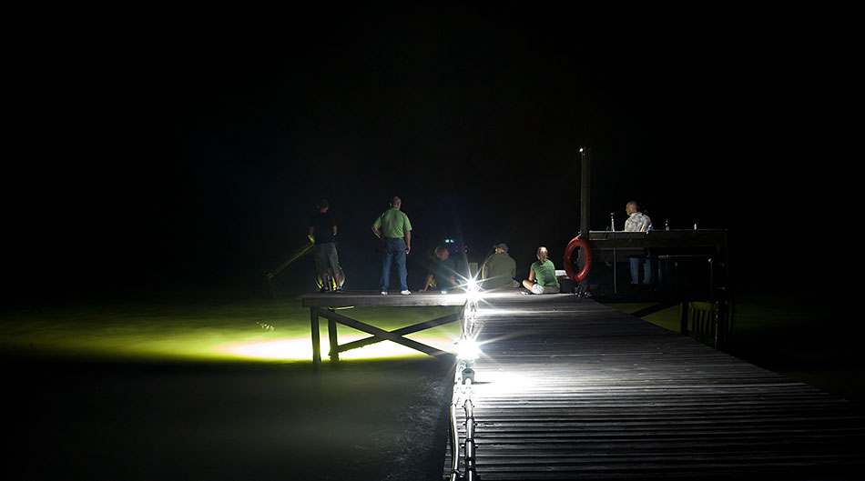 group relaxing on a dark fishing dock