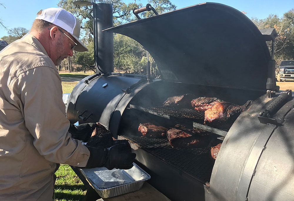 man at a meat smoker