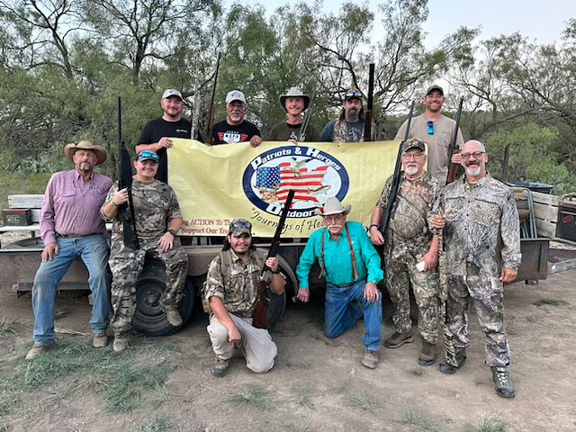 happy Outdoor group with Patriots & Heroes Sign